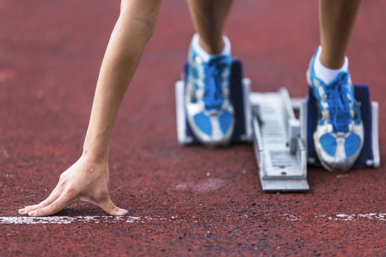 Germany, Young woman running from sprint start